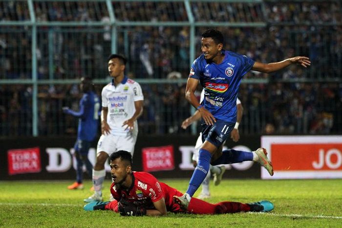 Pemain Arema FC Rivaldi Bawuo menjebol gawang kiper Persib Bandung, M Aqil Savik saat laga tunda Pekan 4 Liga 1 2019 yang berakhir dengan skor 5-1 di Stadion Kanjuruhan Kabupaten Malang, Jawa Timur, Senin (30/07/2019) malam.