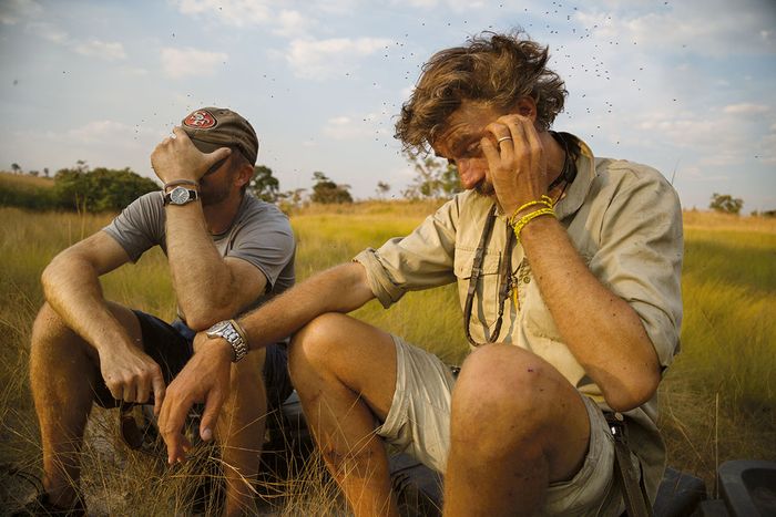 Pemimpin proyek Steve Boyes (kanan) beristirahat bersama Neil Gelinas, pembuat film National Geographic. Di antara tantangan yang dihadapi Boyes selama sepuluh tahun lebih melindungi Okavango—diplomasi, kapal terbalik, ranjau darat—serangan lebah tidaklah istimewa.