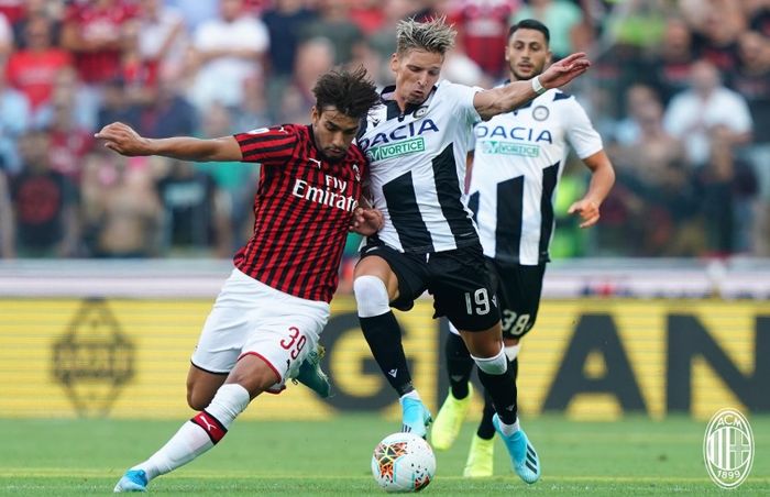 Lucas Paqueta dan Jens Strygen Larsen saling berebut bola pada pertandingan Udinese melawan AC Milan pada pekan perdana Liga Italia di Stadion Dacia Arena, Minggu (25/8/2019).