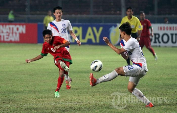 Kapten timnas U-19 Indonesia, Evan Dimas Darmono (kiri) menjebol gawang timnas U-19 Korea Selatan, Kualifikasi Piala Asia Grup G Piala Asia U-19 2014, di Stadion Utama Gelora Bung Karno (SUGBK), Senayan, Jakarta Pusat, Sabtu (12/10/2013).