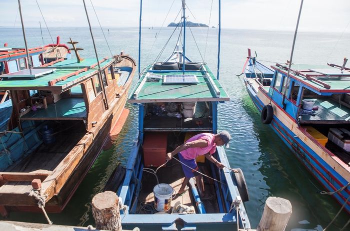 Aktifitas nelayan saat bersiap untuk melaut di Teluk Baruk, Sepempang, Natuna, Selasa, 8 Oktober 2019. Nelayan di Pulau Natuna memanfaatkan lempengan panel tenaga surya yang dipasang di atap kapal mereka untuk mengisi daya aki sehingga kapal mempunyai listrik saat melaut selama sepekan.
