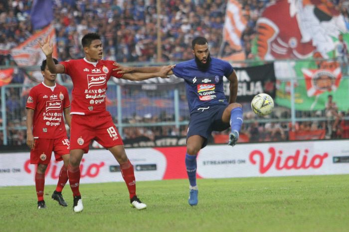 Striker Arema FC , Sylvano Comvalius berebut bola dengan bek Persija Jakarta, Fachruddin Aryanto dalam lanjutan Liga 1 di Stadion Kanjuruhan Kepanjen, Kabupaten Malang, Sabtu (23/11/2019). Arema FC ditahan imbang Persija Jalarta dengan skor 1-1. 