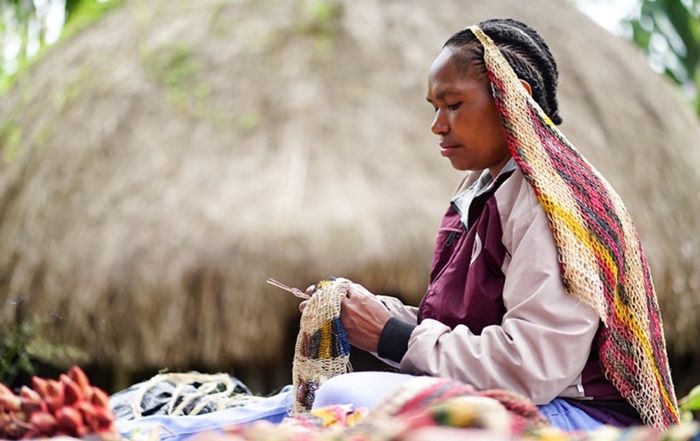 Salomina Pabika menyelesaikan pembuatan noken di Jalan Anelagak Hotel Jerman, Kampung Yumugima, Distrik Siepkosi, Kabupatten Jayawijaya, Papua. Salomina merupakan salah satu penggerak masyarakat perempuan di Kelompok Kerajinan Noken Humi Soge yang memproduksi noken dan mengembangkannya menjadi produ