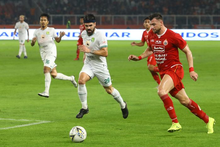 Pemain Persija Jakarta, Marko Simic, berebut bola dengan pemain Persebaya Surabaya, Aryn Williams, di laga pekan ke-33 Liga 1 di Stadion Utama Gelora Bung Karno, Jakarta, Selasa (17/12/2019).