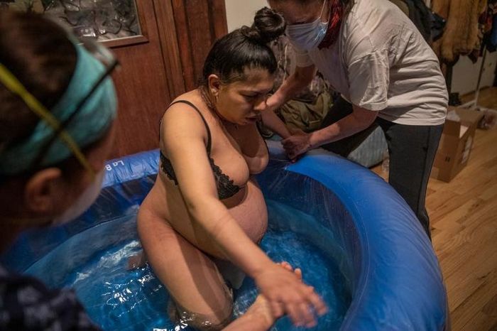 5:58 P.M. Bonsignore memanjat ke kolam persalinan dengan bantuan Clarke, doula-nya, dan bidan Cara Muhlhahn, benar.