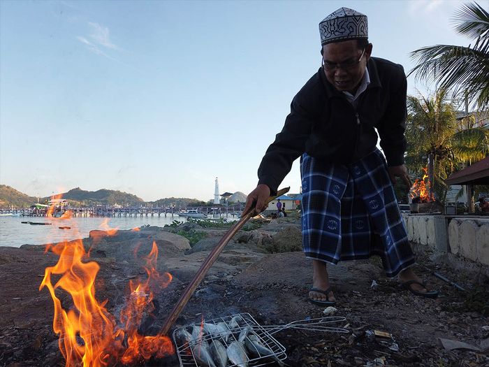 Kegiatan warga Kampung Air pada pagi hari, menanti datangnya kapal ikan keci berlabuh dan beberapa warga senior akan membakar ikan untuk menu sarapan bersama.