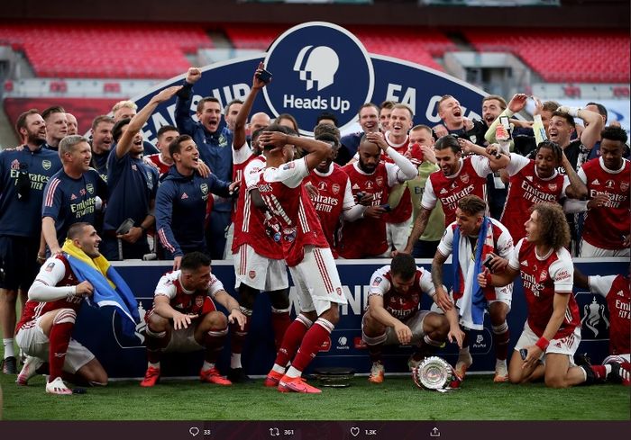 Striker Arsenal, Pierre-Emerick Aubameyang, menjatuhkan trofi saat selebrasi juara Piala FA.