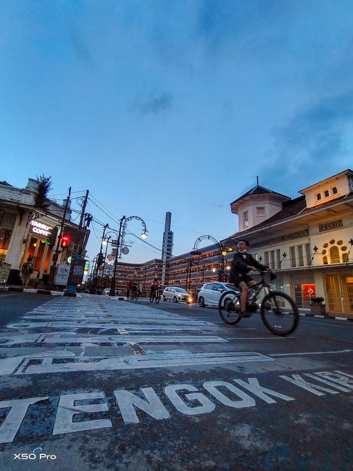 Menara Art-Deco Hotel Savoy Homann tampak menjadi tengara kawasan muara Jalan Braga yang semarak dengan lampu-lampu kota dan langit temaram biru senja.