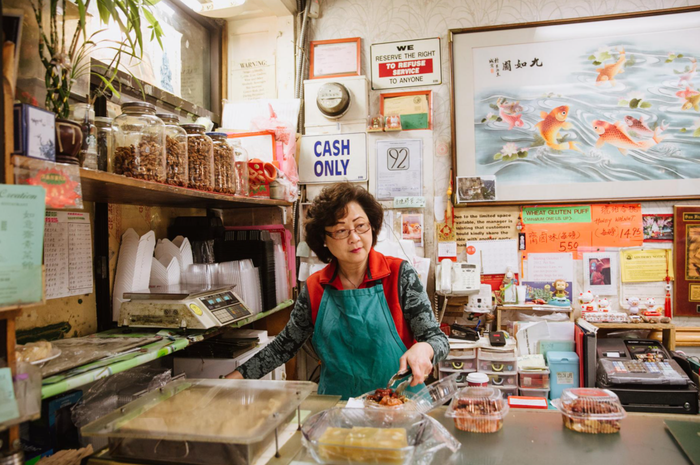 Sau Ling, pemilik restoran The Lucky Creation Vegetarian, digambarkan di etalase tokonya di Pecinan San Francisco pada tahun 2016.
