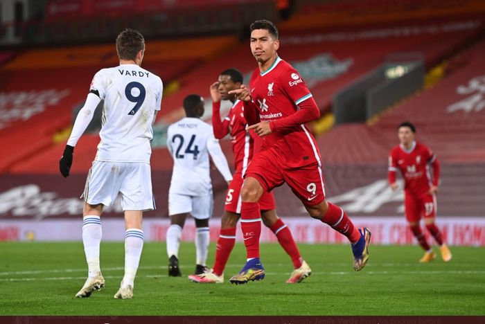 Penyerang Liverpool, Roberto Firmino, melewati Jamie Vardy usai mencetak gol ke gawang Leicester City dalam kemenangan 3-0 di Anfield dalam lanjutan Liga Inggris 2020-2021.