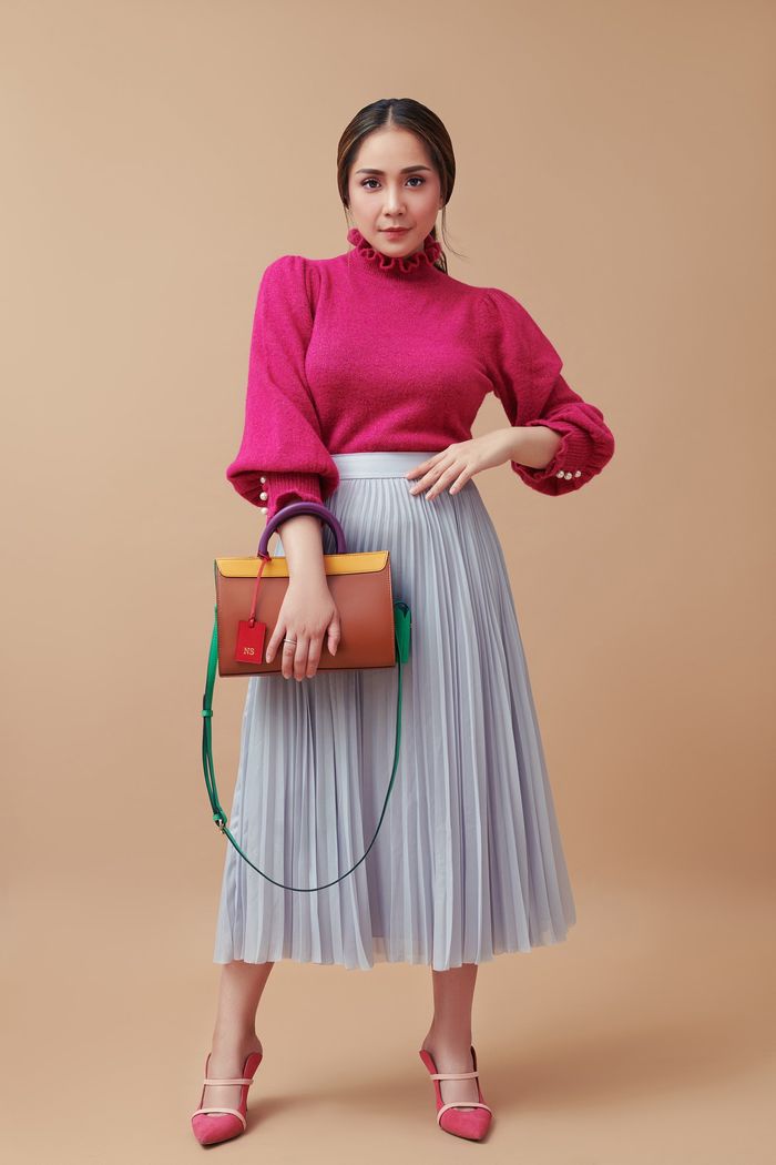 Nagita Slavina dalam balutan sweater merah dan rok pleated