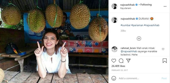 Najwa Shihab berfoto bersama durian sambil tersenyum lebar.