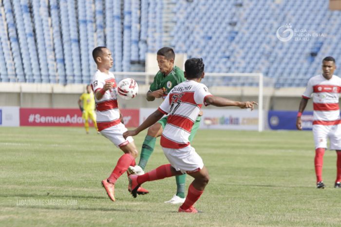 Gelandang PSS Sleman, Irfan Bachdim, berduel dengan pemain Madura United, Slamet Nurcahyono, pada laga perdana Grup C Piala Menpora 2021.
