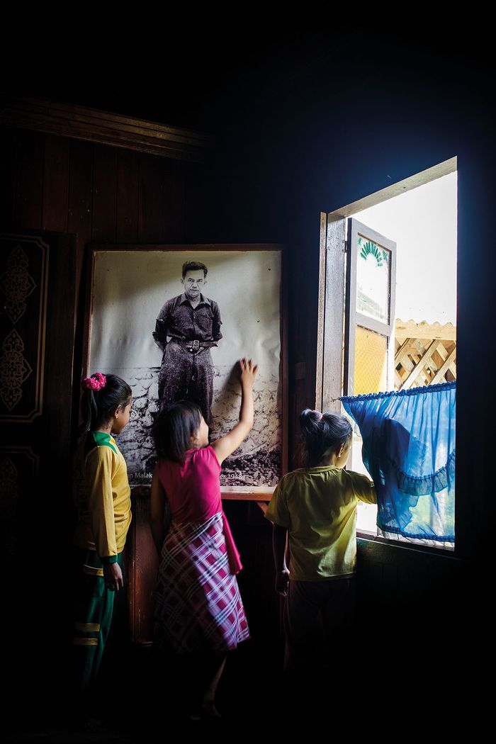 Beberapa anak perempuan bercengkrama di dekat gambar Tan Malaka.