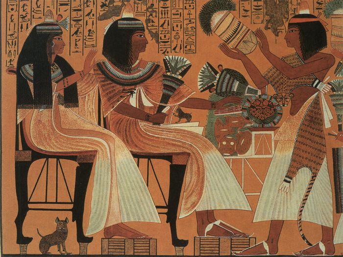 Lukisan dinding, Makam Ipuy Deir el-Medina, sekitar 1250 SM. Ada anak kucing di pangkuan Ipuy, dan induk kucing berada di bawah kursi istrinya, Duammeres. Dari buku The Cat in Ancient Egypt karya Jaromir Malek, University of Pennsylvania Press.