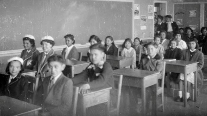 Siswa di kelas di Kuper Island Residential School (Sekolah Perumahan Pulau Kuper). Sekolah ini beroperasi dari 1890 hingga 1970-an di Pulau Penelakut, yang dulunya bernama Pulau Kuper. 