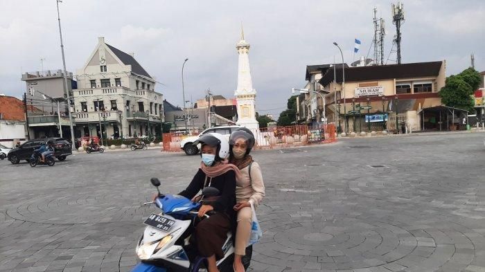 Pengendara sepeda motor yang melintas di Tugu Pal Putih Yogyakarta taat prokes dengan mengenakan masker, Minggu (24/1/2021) 