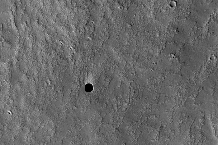 Tampak seperti lubang di permukaan Mars yang mungkin berisi gua, ditangkap oleh kamera HiRISE Mars Reconnaissance Orbiter.