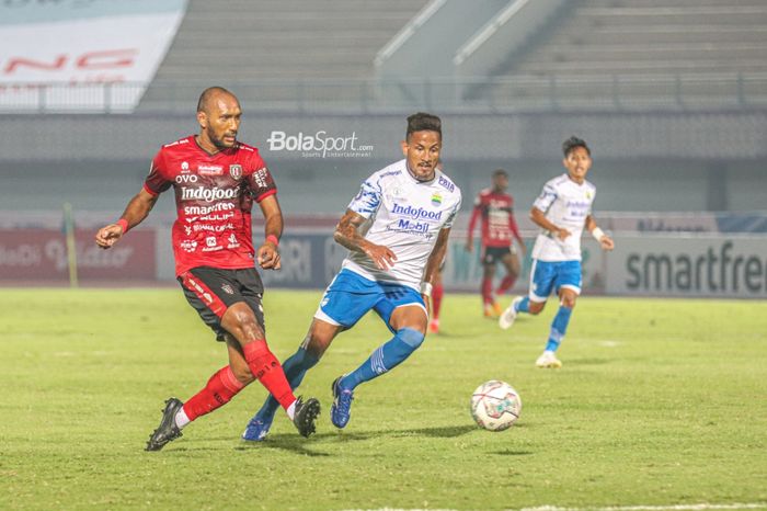 Bek Bali United, Leonard Tupamahu (kiri) sedang mengoper bola dan dikawal ketat striker Persib Bandung, Wander Luiz (kanan), dalam laga pekan ketiga Liga 1 2021 di Stadion Indomilk Arena, Tangerang, Banten, 18 September 2021.