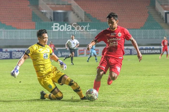 Kiper Persela Lamongan, Dwi Kuswanto (kiri), nampak berusaha menghalau pergerakan pemain Persija Jakarta, Osvaldo Haay (kanan), dalam laga pekan keempat Liga 1 2021 di Stadion Pakansari, Bogor, Jawa Barat, 24 September 2021.