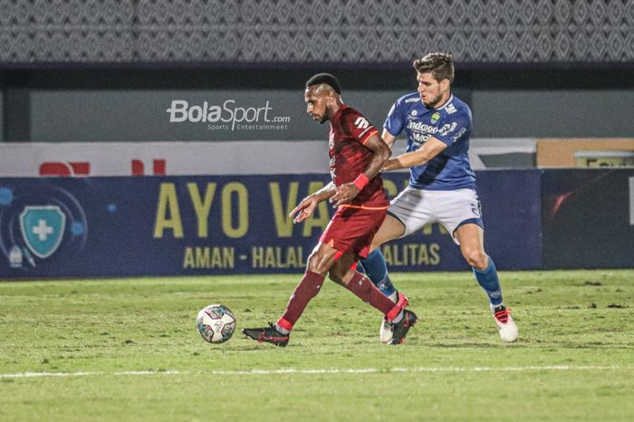 Striker Borneo FC, Boaz Solossa (kiri), sedang menguasai bola dan dijaga ketat oleh bek Persib Bandung, Nick Kuipers (kanan), dalam laga pekan keempat Liga 1 2021 di Stadion Indomilk Arena, Tangerang, Banten, 23 September 2021.