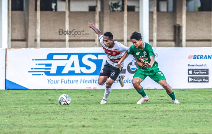 Bek sayap kanan Madura United,Dodi Alekvan Djin (kiri), sedang menguasai bola dan dibayangi oleh pemain PSS Sleman, Hokky Caraka (kanan), dalam laga pekan keempat Liga 1 2021 di Stadion Madya, Senayan, Jakarta, 2 Oktober 2021.