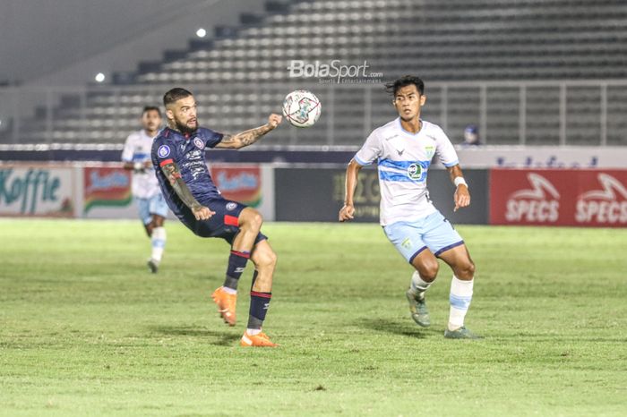 Bek sayap kanan Arema FC, Diego Michiels (kiri), nampak akan menyapu bola yang mengarah ke pemain Persela Lamongan, Malik Risaldi (kanan), dalam laga pekan keenam Liga 1 2021 di Stadion Madya, Senayan, Jakarta, 3 Oktober 2021. 