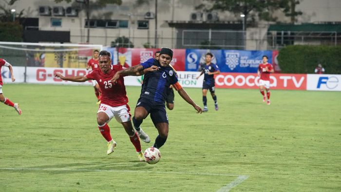 Pemain timnas Indonesia, Irfan Jaya, berduel dengan pemain timnas Kamboja, Sambath Tes, dalam laga perdana Piala AFF 2020, Kamis (9/12/2021).