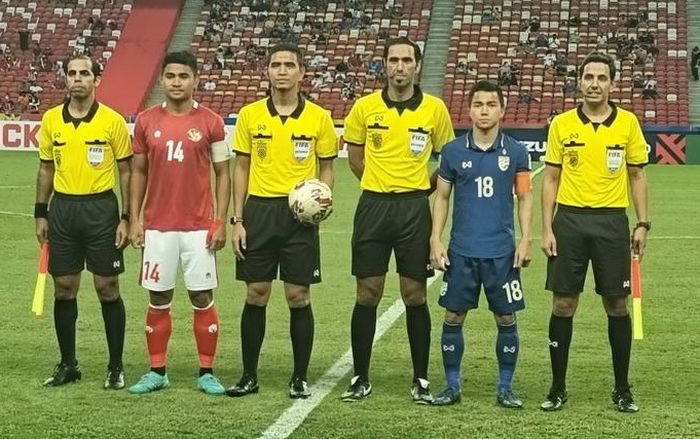 Kapten timnas Indonesia, Asnawi Mangkualam, dan kapten Thailand, Chanathip Songkrasin, berfoto bersama wasit jelang laga leg pertama final Piala AFF 2020.