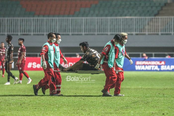 Bek RANS Cilegon FC, Hamka Hamzah, nampak sedang ditandu keluar lapangan dalam laga final Liga 2 2021 di Stadion Pakansari, Bogor, Jawa Barat, 30 Desember 2021.