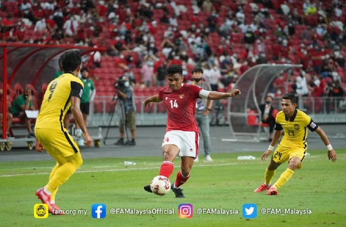 Kapten Timnas Indonesia Asnawi Mangkualam Bahar (tengah) dikepung dua pemain Malaysia dalam duel Grup B Piala AFF 2020.