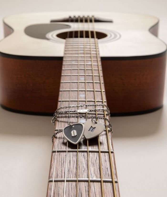 Guitar pick necklace sebagai merchandise official sang rapper.