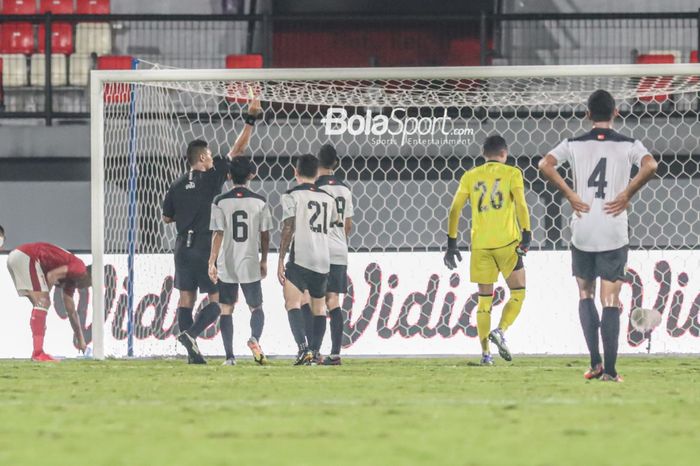 Wasit memberikan kartu kuning kepada kiper timnas Indonesia, Syahrul Trisna Fadillah (jersey kuning), setelah melanggar salah satu pemain timnas Timor Leste di Stadion Kapten I Wayan Dipta, Gianyar, Bali, 27 Januari 2022.