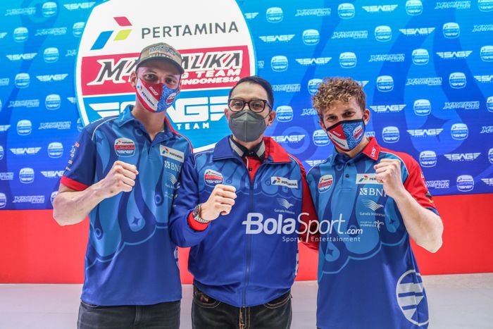 Dua pembalap Mandalika Racing Team Indonesia (Pertamina Mandalika SAG), Bo Bendsneyder (kiri) dan Gabriel Rodrigo (kanan), berfoto bersama Charles Bonar Sirait (tengah) selaku Direktur Komunikasi Strategi dan Pengembangan Bisnis Mandalika Racing Team Indonesia di Kawasan Epicentrum, Jakarta Selatan,