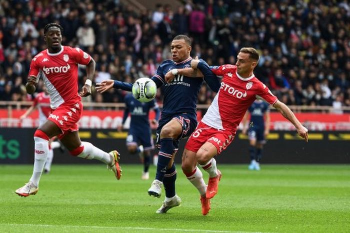 Kylian Mbappe (tengah) dikawal ketat dalam partai Liga Prancis antara AS Monaco vs Paris Saint-Germain di Louis II, Monako (20/3/2022).