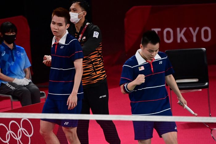 Pasangan ganda putra Malaysia, Soh Wooi Yik dan Aaron Chia, bersama pelatih,  Flandy Limpele, bereaksi setelah kemenangan atas Marcus Fernaldi Gideon/Kevin Sanjaya Sukamuljo (Indonesia) pada perempat final Olimpiade Tokyo 2020 di Musashino Forest Sports Plaza, Tokyo, Jepang, 29 Juli 2021.