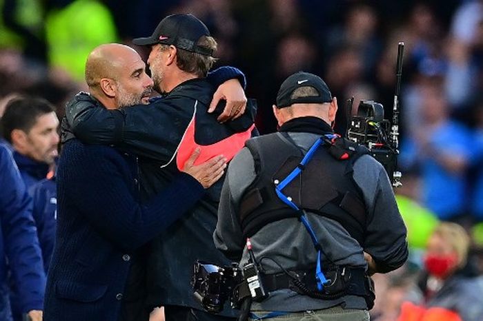 Pelatih Manchester City, Pep Guardiola, memeluk pelatih Liverpool, Juergen Klopp, seusai laga Liga Inggris di Stadion Anfield, 3 Oktober 2021.