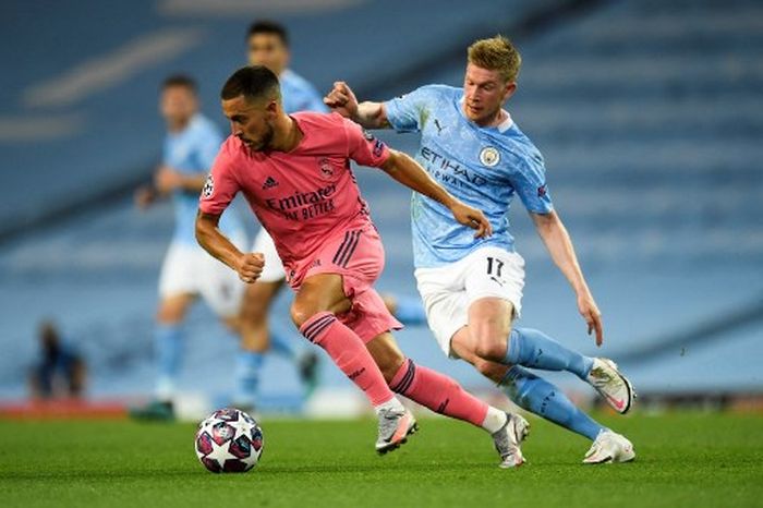 Eden Hazard (kiri) berebut bola dengan Kevin de Bruyne dalam duel Liga Champions antara Manchester City vs Real Madrid di Etihad Stadium (7/8/2020).