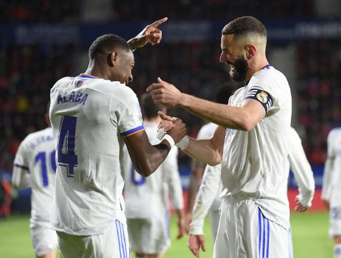 Bek Real Madrid, David Alaba, merayakan gol bareng Karim Benzema dalam laga Liga Spanyol kontra Osasuna di Stadion El Sadar, Rabu (20/4/2022).