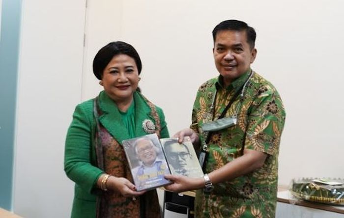 Dewan Kehormatan Perhumas Prita Kemal Gani menerima buku tentang perintis Kompas Gramedia (KG) Jakob Oetama dan P.K. Ojong dari Direktur Kerja Sama Antarlembaga Kompas Rusdi Amral, dalam acara pertemuan Perhumas dan KG Media di Menara Kompas, pada Jumat (22/4/2022).