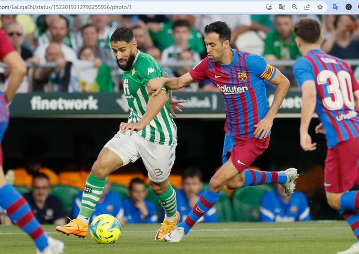 Nabil Fekir (kiri) dan Sergio Busquets (kanan) berebut bola dalam laga antara Real Betis dan Barcelona di Estadio Benito Villamarin pada Sabtu (7/5/2022) waktu setempat.