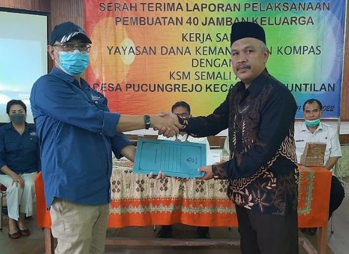 Manajer Eksekutif Yayasan Dana Kemanusiaan Kompas Anung Wendyartaka (kiri) menerima laporan pelaksanaan pembuatan 40 jamban keluarga di Desa Pucungrejo, Kecamatan Muntilan, Kabupaten Magelang, Jawa Tengah, Rabu (11/5/2022). Laporan diserahkan oleh Ketua KSM Semali Asri Fahrudin (kanan).