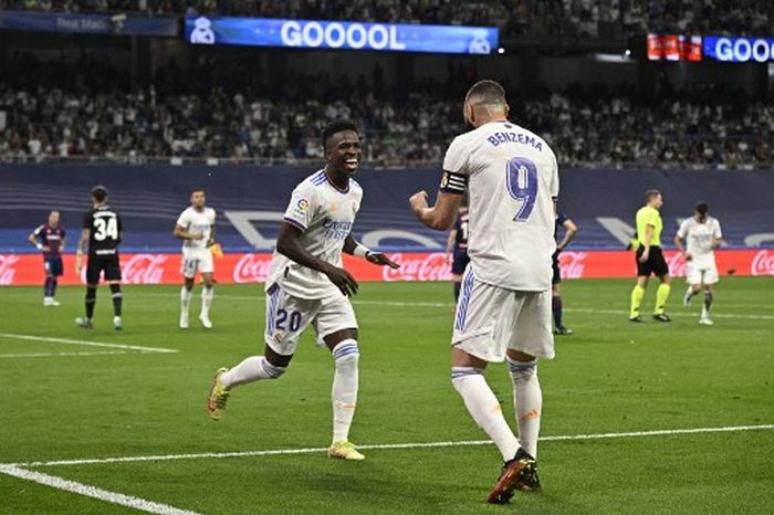 Penyerang Real Madrid, Vinicius Junior, merayakan gol bareng Karim Benzema dalam laga Liga Spanyol kontra Levante di Stadion Santiago Bernabeu, Kamis (12/5/2022).