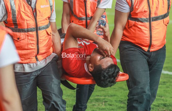 Bek timnas Indonesia, Asnawi Mangkualam ditandu keluar lapangan.