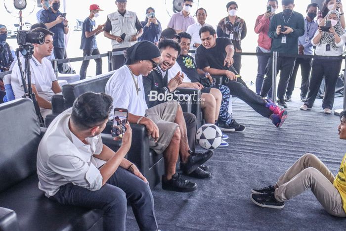 Ronaldinho (tengah) sedang beraksi juggling di depan Raffi Ahmad (kiri) dan Rudy Salim di Sport Center RANS Nusantara FC, Pantai Indah Kapuk, Tangerang, Banten, 27 Juni 2022.