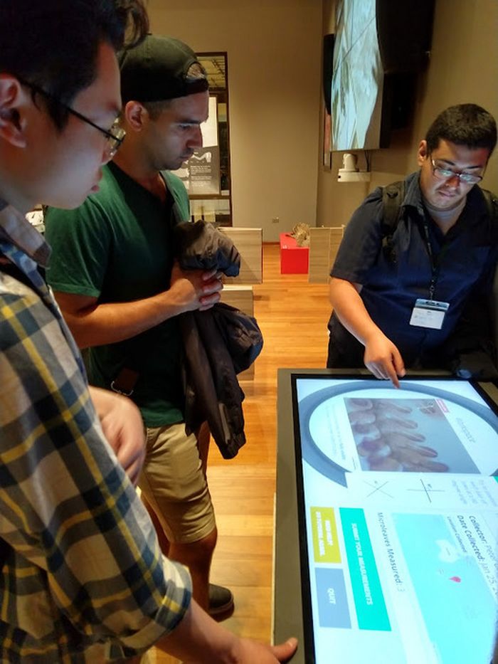 Cuong Pham, Jimmy Crigler, dan Joshua Torres, saat itu mahasiswa di Universitas Roosevelt, bekerja pada platform sains warga dalam sebuah pameran di Field Museum, Chicago, AS.
