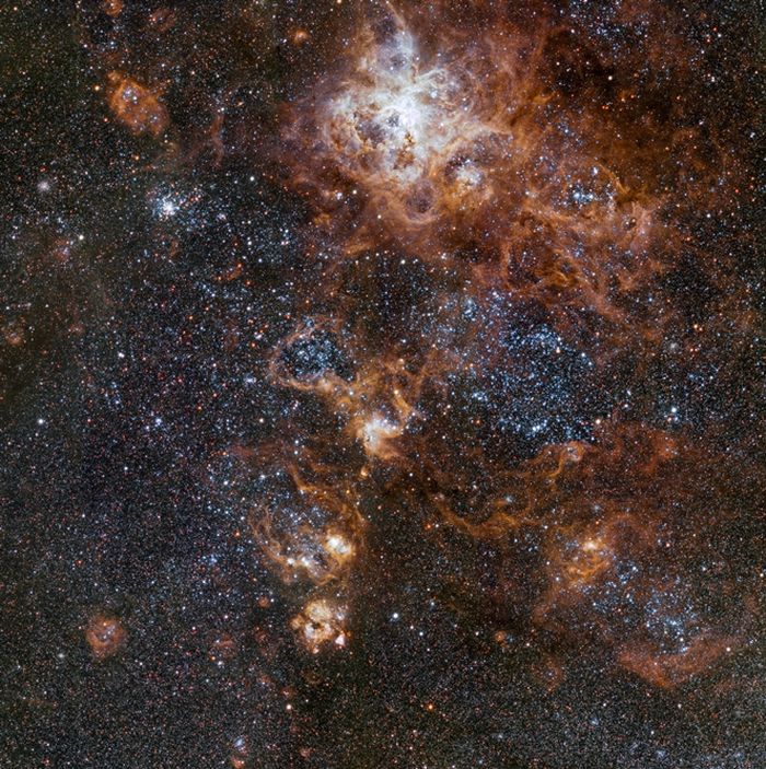 Bersinar terang sekitar 160.000 tahun cahaya jauhnya, Nebula Tarantula adalah fitur paling spektakuler dari Awan Magellan Besar, galaksi satelit Bima Sakti. Gambar dari VLT Survey Telescope di Observatorium Paranal ESO di Chili ini menunjukkan wilayah tersebut dan sekitarnya yang kaya dengan sangat detail.