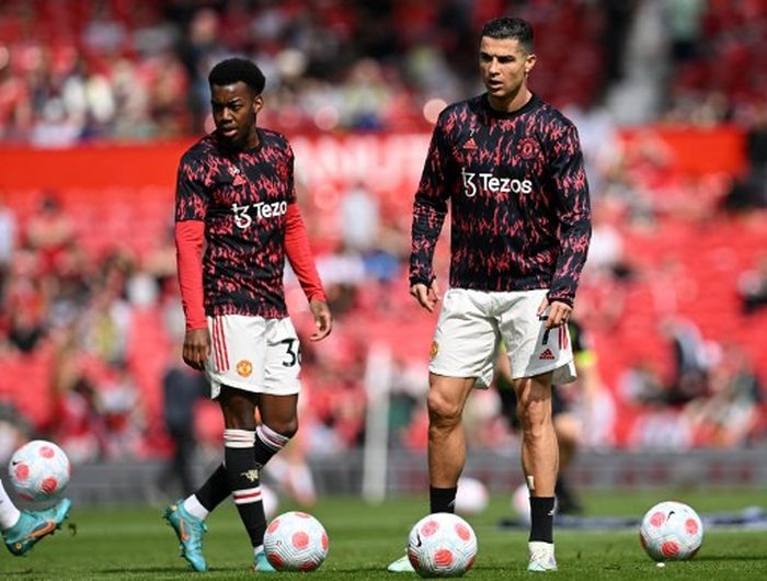 Cristiano Ronaldo (kanan) bersama Anthony Elanga dalam sesi pemanasan Manchester United jelang duel Liga Inggris kontra Norwich di Old Trafford (16/4/2022).