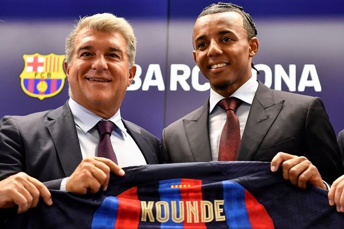 Presiden Barcelona, Joan Laporta, berpose bersama bek tengah baru El Barca, Jules Kounde, di tempat latihan Joan Gamper, 1 Agustus 2022.