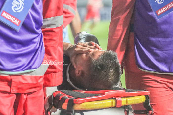 Pemain Persikabo 1973, Manahati Lestusen, nampak menutupi wajahnya saat ditandu keluar lapangan Striker Persija Jakarta, Abdulla Yusuf Abdulrahim Mohamed Helal (kanan), sedang berduel udara menyundul bola dalam laga pekan keempat Liga 1 2022 di Stadion Pakansari, Bogor, Jawa Barat, 14 Agustus 2022.